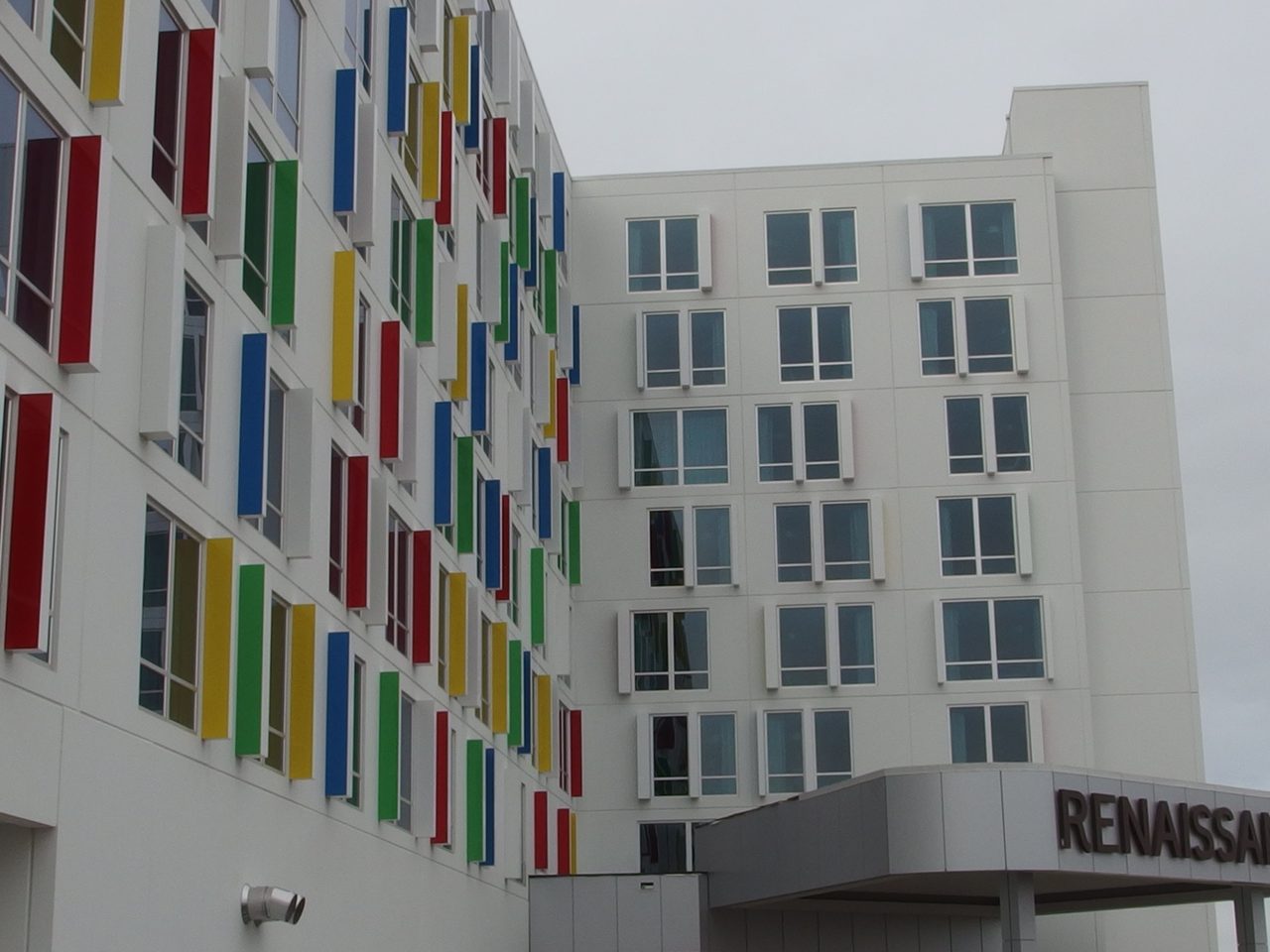 Photograph of the Renaissance Edmonton Airport Hotel: a white facade with red, yellow, blue and green window fins